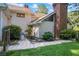 Exterior side view features a stone patio and walkway, complemented by lush landscaping and blooming flowers at 1961 Luke Edwards Rd, Dacula, GA 30019