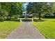 Two story exterior elevation showcases a lush green yard with mature shade trees and a grand entrance at 1961 Luke Edwards Rd, Dacula, GA 30019