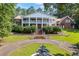 Stately two-story brick home with white columns and a circular driveway featuring a charming water fountain at 1961 Luke Edwards Rd, Dacula, GA 30019