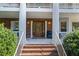 Charming front porch with brick steps, columns, and a decorative wood front door with sidelight windows at 1961 Luke Edwards Rd, Dacula, GA 30019