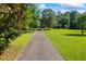 Expansive front yard with a long driveway leading to the house, framed by lush greenery and mature trees at 1961 Luke Edwards Rd, Dacula, GA 30019