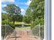 View of the long front yard featuring a fountain and mature trees, as seen from the front porch staircase at 1961 Luke Edwards Rd, Dacula, GA 30019