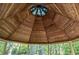 Detailed gazebo ceiling showcasing wood beams and blue stained glass centerpiece surrounded by a natural forest setting at 1961 Luke Edwards Rd, Dacula, GA 30019