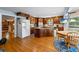 Spacious kitchen with wood cabinets, white appliances, a center island with cooktop, and hardwood floors at 1961 Luke Edwards Rd, Dacula, GA 30019