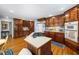 Spacious kitchen with cherry wood cabinets, island cooktop, built-in appliances, and hardwood floors at 1961 Luke Edwards Rd, Dacula, GA 30019