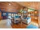 Inviting living room with wood paneled vaulted ceiling, stone fireplace, and backyard views at 1961 Luke Edwards Rd, Dacula, GA 30019