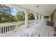 Relaxing covered porch framed by white columns and wood flooring at 1961 Luke Edwards Rd, Dacula, GA 30019
