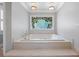Main bathroom tub with custom stained-glass window at 1961 Luke Edwards Rd, Dacula, GA 30019