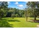 Lush green lawn with scattered trees, creates a tranquil and inviting outdoor space perfect for relaxation and recreation at 1961 Luke Edwards Rd, Dacula, GA 30019
