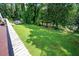 A sprawling backyard showcasing lush lawn, mature trees and a shed on the edge at 2302 Springside Way, Decatur, GA 30032