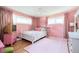 Charming pink bedroom featuring light hardwood floors, two windows, and vintage furniture at 2302 Springside Way, Decatur, GA 30032