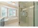 Bright bathroom with glass-enclosed shower, tub, and windows for natural light at 4120 Grady Smith Rd, Loganville, GA 30052
