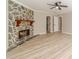 Well-lit living room features a stone fireplace and natural light with hardwood floors at 4120 Grady Smith Rd, Loganville, GA 30052