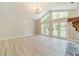 Open and bright living room with French doors, a stone fireplace, and light hard wood flooring at 4120 Grady Smith Rd, Loganville, GA 30052