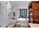 Luxurious bathroom with a freestanding tub, glass shower, and decorative stool, designed for relaxation at 4385 Pinehollow Court Ct, Alpharetta, GA 30022