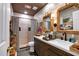 Modern bathroom featuring wood cabinets, a large vanity, and a stand up shower with stone floors at 4385 Pinehollow Court Ct, Alpharetta, GA 30022