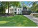 Charming white-brick home featuring a well-manicured lawn and a two-car garage with an American flag at 4385 Pinehollow Court Ct, Alpharetta, GA 30022