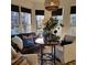 Cozy sun room with oversized windows, a leather sofa, and charming decor at 4385 Pinehollow Court Ct, Alpharetta, GA 30022