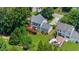 Aerial view showcasing the home, backyard with deck, and surrounding lush greenery at 1410 Kingfield Dr, Johns Creek, GA 30005