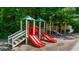 Community playground featuring slides and climbing structures surrounded by mature trees at 1410 Kingfield Dr, Johns Creek, GA 30005