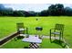 Backyard patio with chairs, a grill, and a table overlooking a expansive green space with a picnic shelter at 7104 Georges Way, Morrow, GA 30260