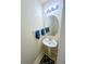 Half bathroom featuring a pedestal sink, round mirror, accent lighting, and a neutral color scheme at 7104 Georges Way, Morrow, GA 30260