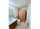 Cozy bathroom featuring a shower with an orange patterned curtain and neutral-toned decor at 7104 Georges Way, Morrow, GA 30260