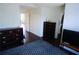 Bedroom with neutral walls, wood floors, dressers, and a glimpse into a walk-in closet at 7104 Georges Way, Morrow, GA 30260