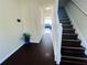 Hallway with wood floors, stairs and a view into the living room; blue hydrangeas add a pop of color at 7104 Georges Way, Morrow, GA 30260