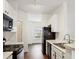 Kitchen featuring white cabinetry, black appliances, and an open view to the dining area at 1731 Pryor Sw Rd # 307, Atlanta, GA 30315