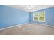 Bedroom with carpeted floors, light blue walls, ceiling fan, and a large window offering natural light at 4140 Riverlook Parkway Se Se Pkwy # 209, Marietta, GA 30067
