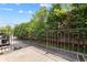 Balcony view with iron railing overlooking lush greenery and trees on a sunny day at 5139 Peachtree Road, Chamblee, GA 30341