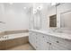 Elegant bathroom with double sink vanity, tile floors, and soaking tub at 5139 Peachtree Road, Chamblee, GA 30341