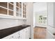 Bright butler's pantry featuring granite countertop and glass front cabinetry at 5139 Peachtree Road, Chamblee, GA 30341