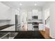 Open kitchen featuring stainless appliances, granite countertops and wood floors at 5139 Peachtree Road, Chamblee, GA 30341