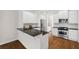 Modern kitchen boasts stainless steel appliances, granite counters, and stylish white cabinets at 5139 Peachtree Road, Chamblee, GA 30341