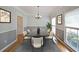 Dining room with hardwood floors, wainscoting, chandelier, and ample natural light at 5176 Shotwell St, Woodstock, GA 30188