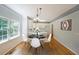 Dining area adjacent to kitchen with stylish table and chairs, hardwood floors, and natural light at 5176 Shotwell St, Woodstock, GA 30188