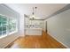 Dining area leading to bright kitchen with hardwood floors and natural light from windows at 5176 Shotwell St, Woodstock, GA 30188