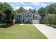Charming two-story home with a well-manicured lawn, a long driveway, and lush landscaping at 5176 Shotwell St, Woodstock, GA 30188