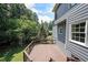 Exterior elevation showing a wooden deck attached to the house with lush greenery in the background at 5176 Shotwell St, Woodstock, GA 30188