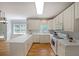 Bright kitchen with white cabinets, hardwood floors, and stainless appliances at 5176 Shotwell St, Woodstock, GA 30188