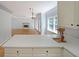 Kitchen with white cabinets, hardwood floors, and open to the living room at 5176 Shotwell St, Woodstock, GA 30188