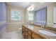 Bathroom with double vanity, stylish granite countertop, window, a large mirror, and wood cabinets at 7045 Hunters Ne Knl, Sandy Springs, GA 30328