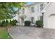 Elegant white brick home with gray shutters, complemented by a meticulously paved driveway and lush landscaping at 7045 Hunters Ne Knl, Sandy Springs, GA 30328