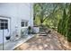 Cozy outdoor patio with seating area next to the house, complemented by landscaped garden and mature trees at 7045 Hunters Ne Knl, Sandy Springs, GA 30328