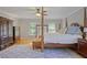 Bright main bedroom boasts a four poster bed, area rug, and windows at 7045 Hunters Ne Knl, Sandy Springs, GA 30328