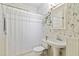 Bright bathroom features a pedestal sink, medicine cabinet, and a shower with decorative wallpaper at 1166 Virginia Avenue Ne Ave # 8, Atlanta, GA 30306
