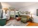 Bright living room featuring hardwood floors, a plush sofa, and sunlit windows adorned with hanging plants at 1166 Virginia Avenue Ne Ave # 8, Atlanta, GA 30306