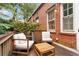 Cozy outdoor space with wooden patio, lush greenery, brick wall, wooden table, and comfortable chairs at 1166 Virginia Avenue Ne Ave # 8, Atlanta, GA 30306